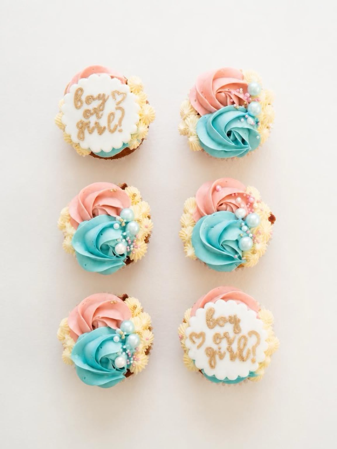 Gender reveal cupcakes with pink and blue buttercream swirls