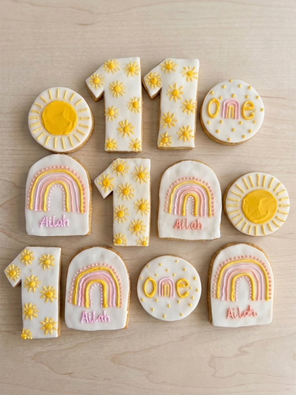 Decorated first birthday cookies with suns, rainbows and name lettering